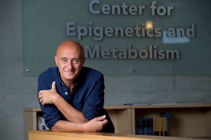 A photo of Paolo Sassone-Corsi in front of a sign that says Center For Epigenetics And Metabolism
